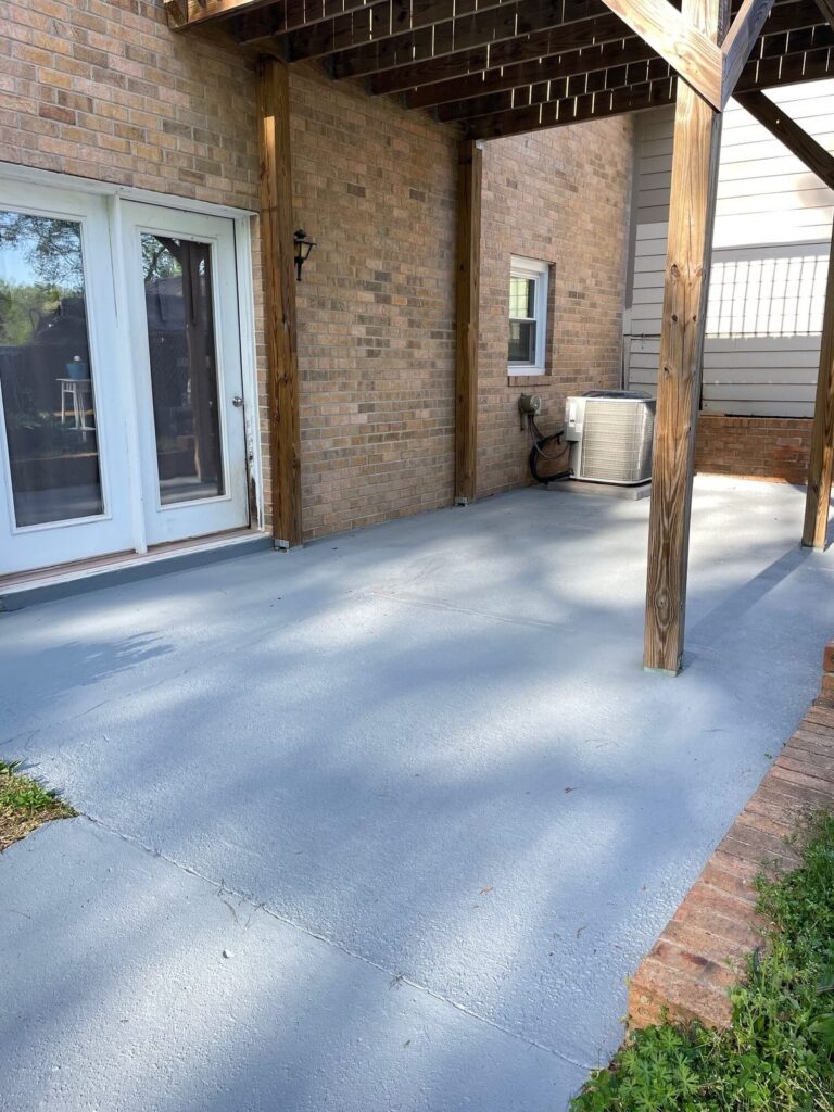 Freshly painted concrete patio under wooden deck structure