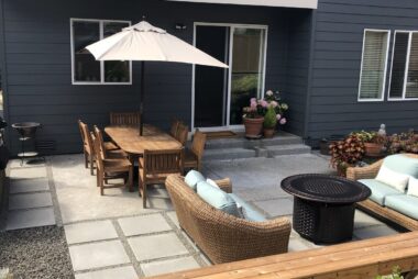 Modern backyard patio with wooden furniture and concrete pavers