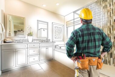Contractor planning bathroom remodel with digital renovation blueprint overlay