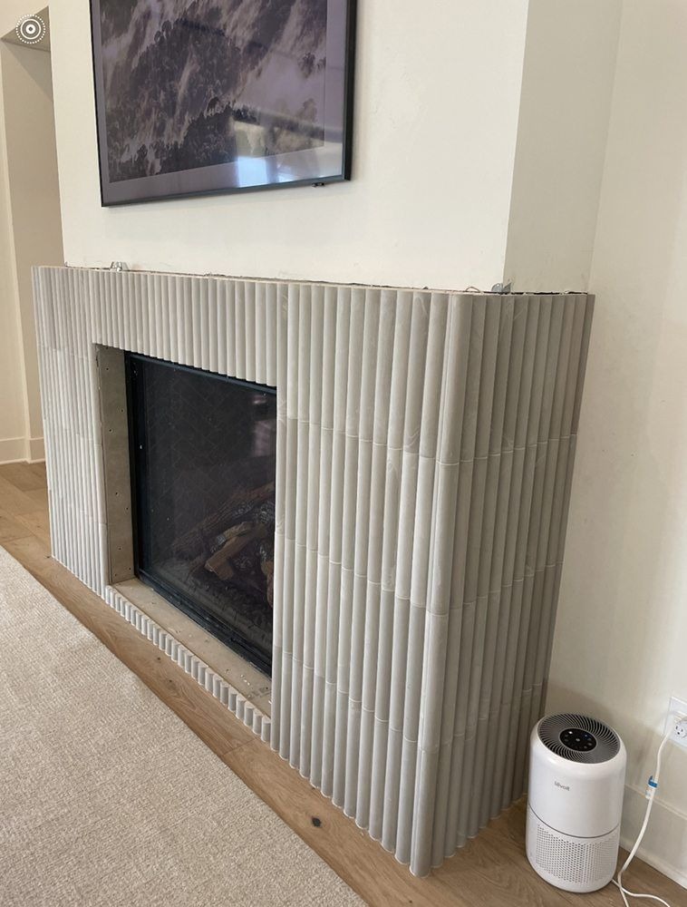 Modern fireplace with vertical tile surround and minimalist wall design