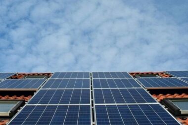 Solar panels installed on red tile roof under blue sky