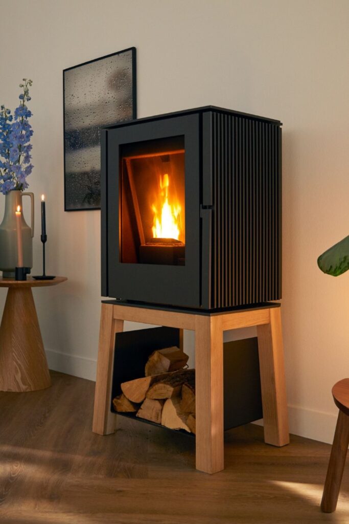 Modern wood stove on wooden stand in cozy living room