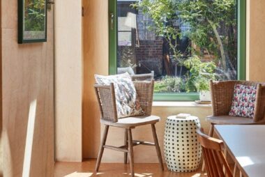 Cozy sunlit reading nook with large green-framed window