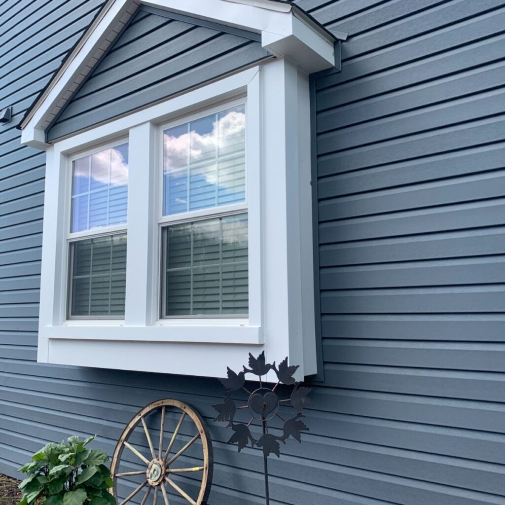 Modern double-pane vinyl window with white trim on siding