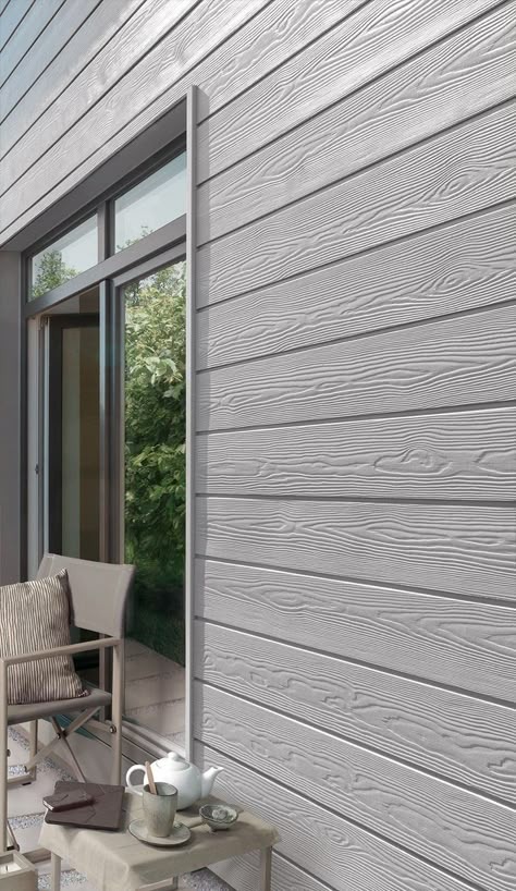 Modern fiber cement siding with wood grain texture and patio