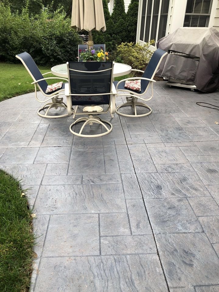 Stamped concrete patio with outdoor dining furniture and umbrella